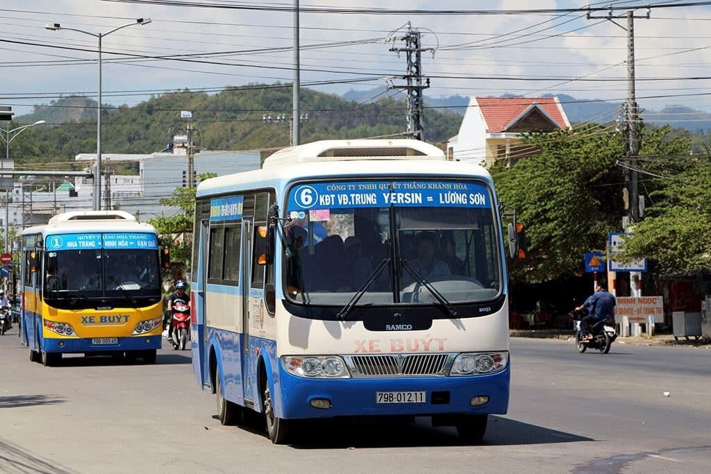 Alt text: Một chiếc xe buýt màu xanh lá cây đang dừng ở trạm chờ, đại diện cho hệ thống giao thông công cộng Nha Trang