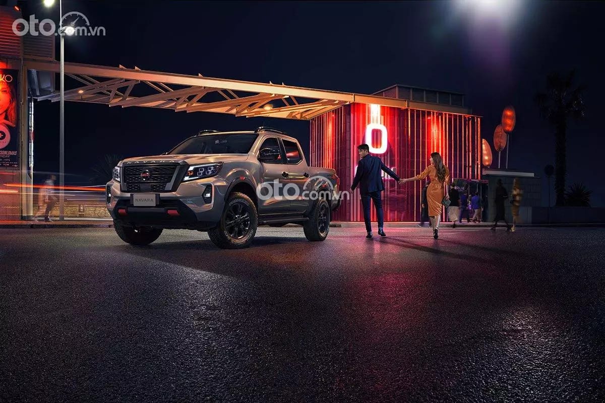 Cận cảnh phần đầu xe bán tải Nissan Navara màu đen với lưới tản nhiệt chrome cỡ lớn và đèn pha sắc sảo, toát lên vẻ hầm hố và hiện đại.