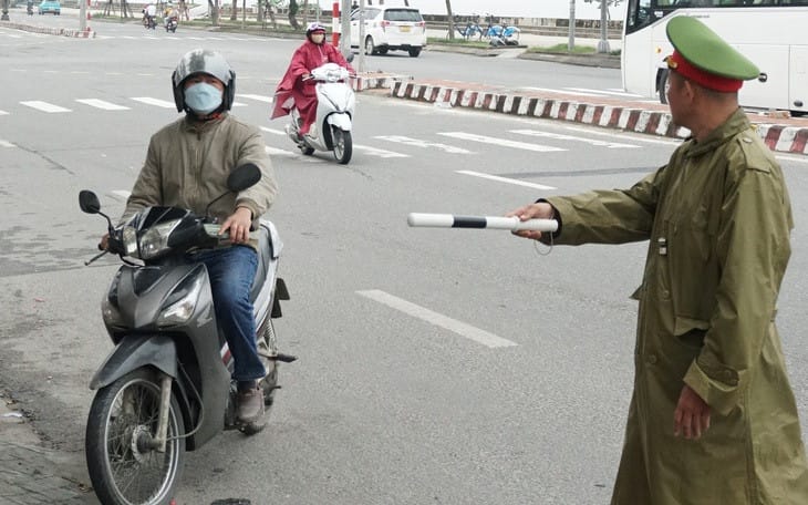 Cảnh sát giao thông đang làm việc với người vi phạm luật, nhấn mạnh tầm quan trọng của việc hiểu rõ quy định đèn đỏ có được rẽ phải không để tránh bị phạt.