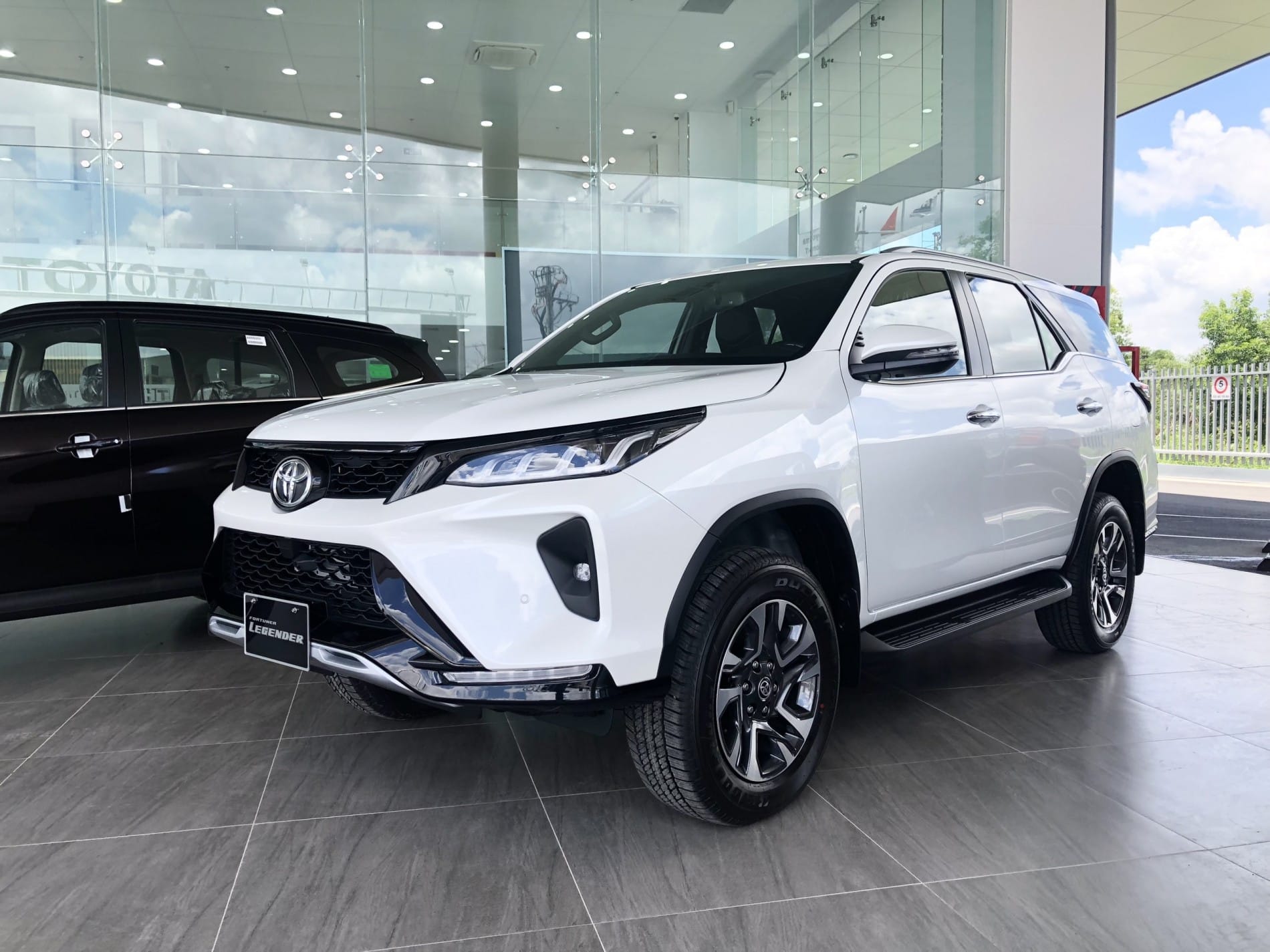 Chiếc Fortuner Legender 2.4AT 4x2 màu trắng bạc nổi bật trên đường phố.