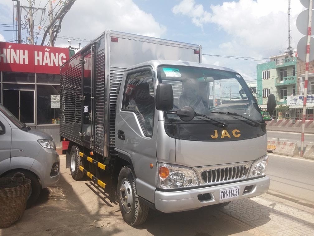 Chiếc xe tải JAC 1.5 tấn cũ màu xanh lá cây đỗ ven đường