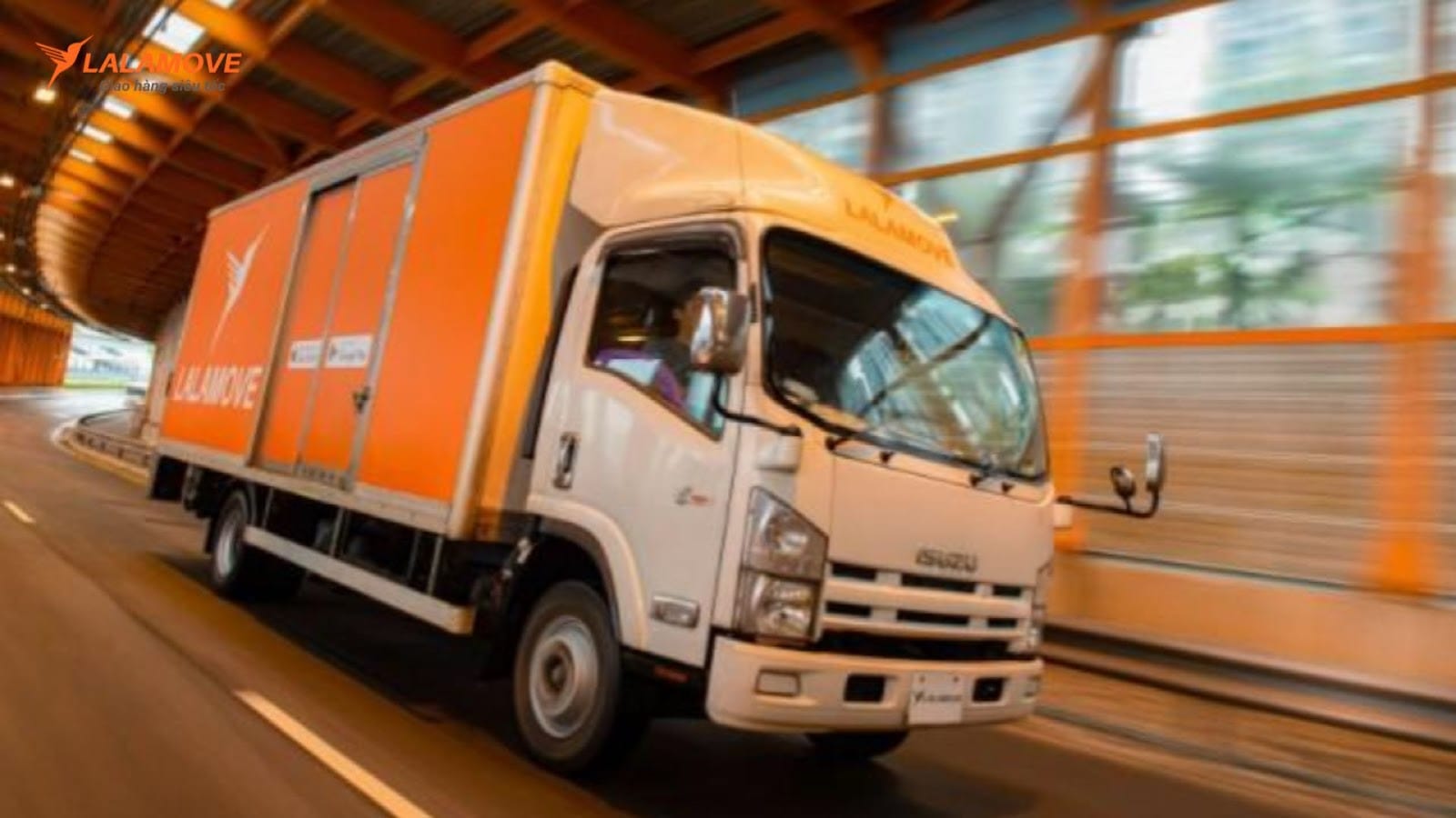 Chủ xe tải sử dụng điện thoại để nhận đơn hàng Lalamove, minh họa việc tăng thu nhập từ xe tải giao hàng Lalamove