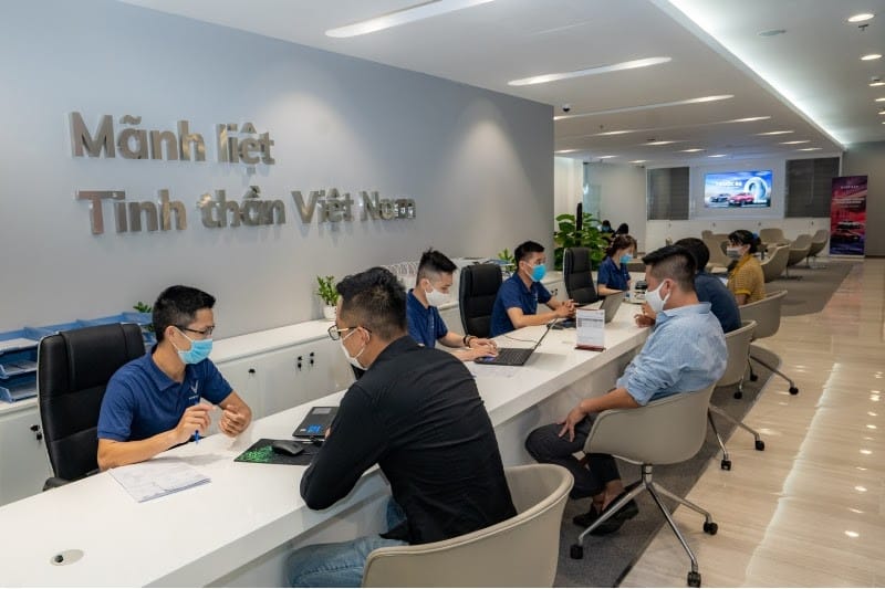 Chuyên viên tư vấn ô tô giải thích tình trạng kỹ thuật của xe cho khách hàng bằng máy tính bảng.