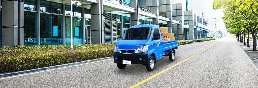Dòng xe tải Thaco Towner 990 màu trắng đang di chuyển trên đường