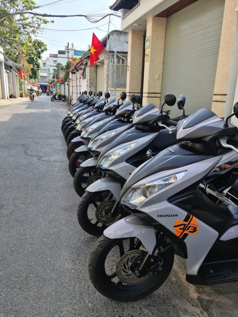 Du khách đang kiểm tra lốp xe máy trước khi thuê, đảm bảo an toàn cho hành trình khám phá Vũng Tàu