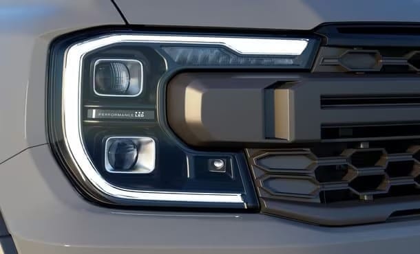 Ford Ranger Raptor 2023 màu cam nổi bật trên địa hình sỏi đá, thể hiện sức mạnh và thiết kế ấn tượng.