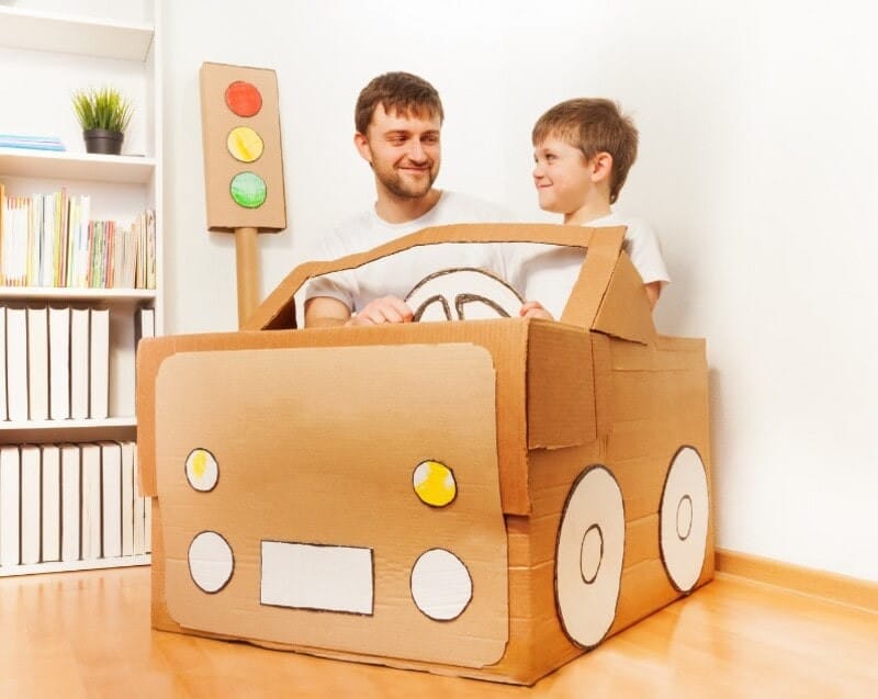 Hai bé vui vẻ chơi với xe tải tự làm từ thùng bìa carton lớn