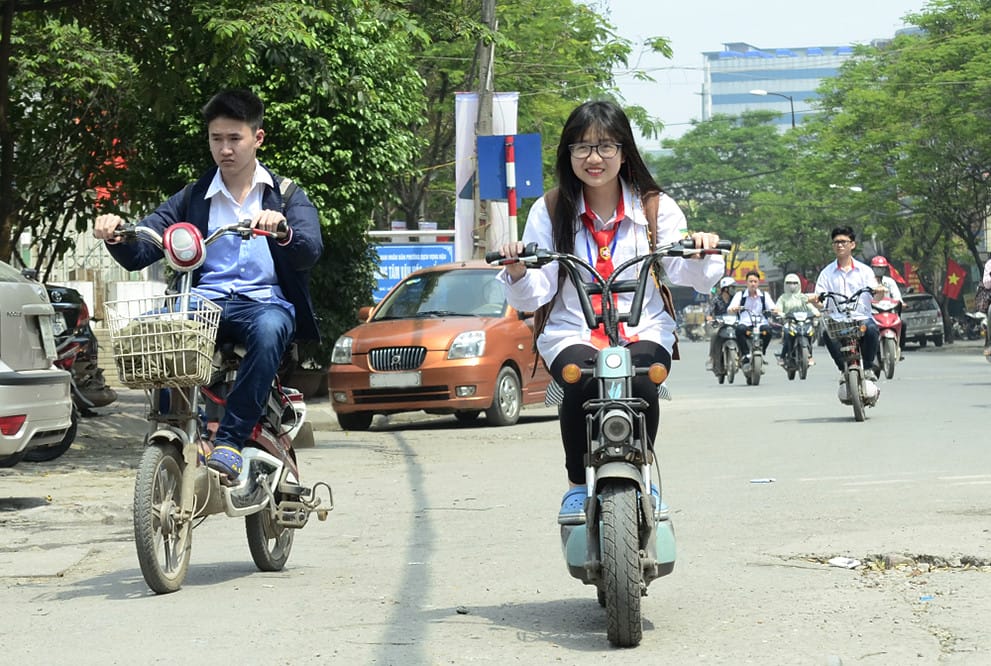 Hình ảnh học sinh cấp 2 điều khiển xe đạp điện trên đường, thể hiện sự phổ biến của phương tiện này trong độ tuổi đi học.