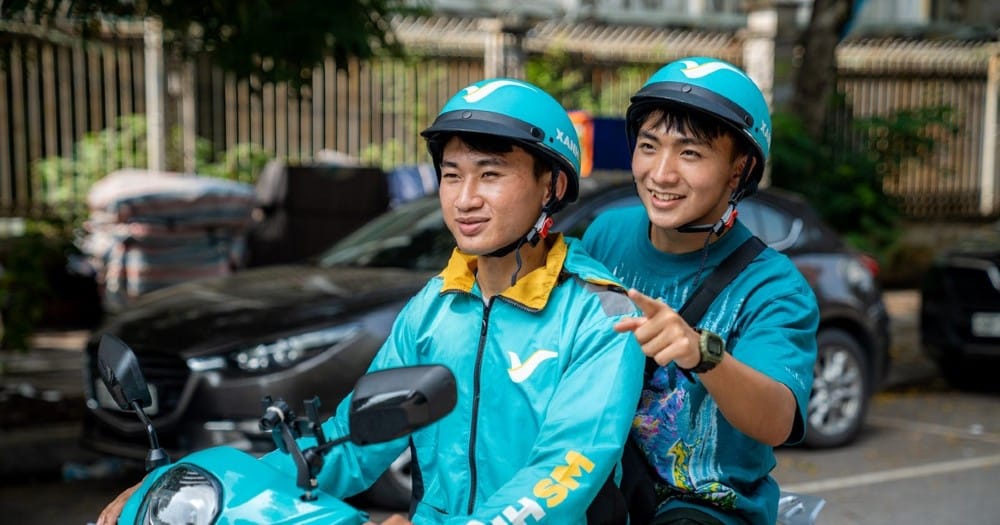 Hình ảnh xe điện Xanh SM đậu gần khu vực cây xanh, thể hiện sự đồng hành cùng du khách