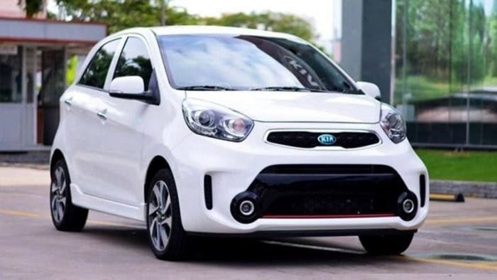 Hình ảnh xe Kia Morning AT màu trắng đỗ trước tòa nhà hiện đại, nhấn mạnh sự tiện lợi trong đô thị
