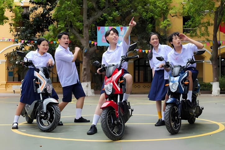 Học sinh di chuyển trên xe đạp điện màu xanh lá, thể hiện tính tiện lợi và phổ biến của dòng phương tiện này với giá xe đạp điện mới nhất đa dạng.