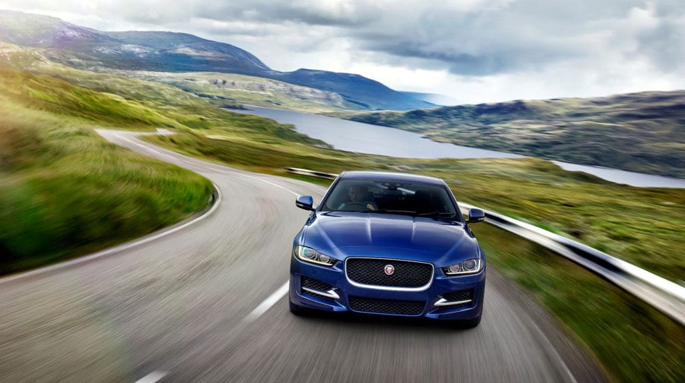 Jaguar F-PACE màu xanh lam, với thiết kế năng động và thể thao, đứng trên một con đường cảnh đẹp