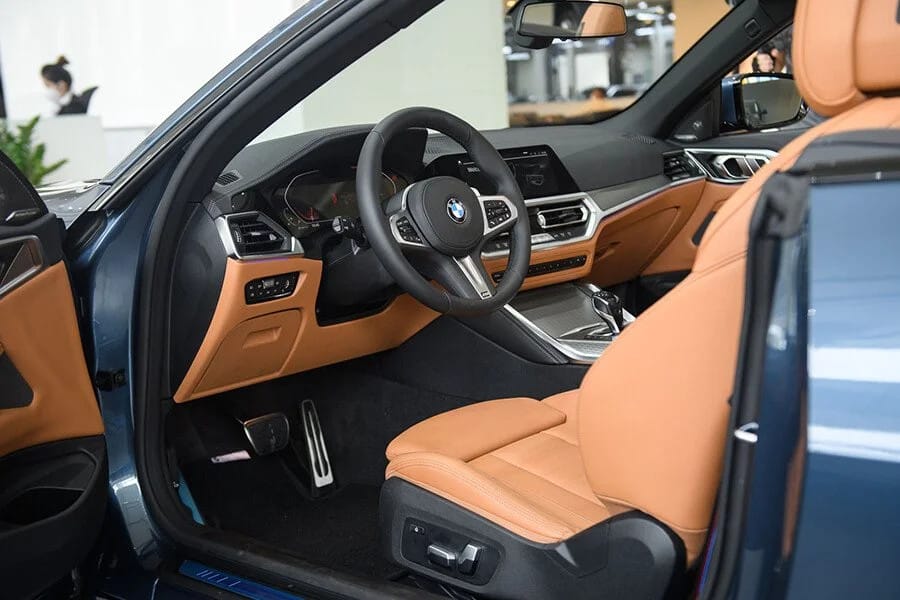Khoang nội thất sang trọng của BMW 430i mui trần, hiển thị màn hình trung tâm và các chi tiết ốp nhôm cao cấp.