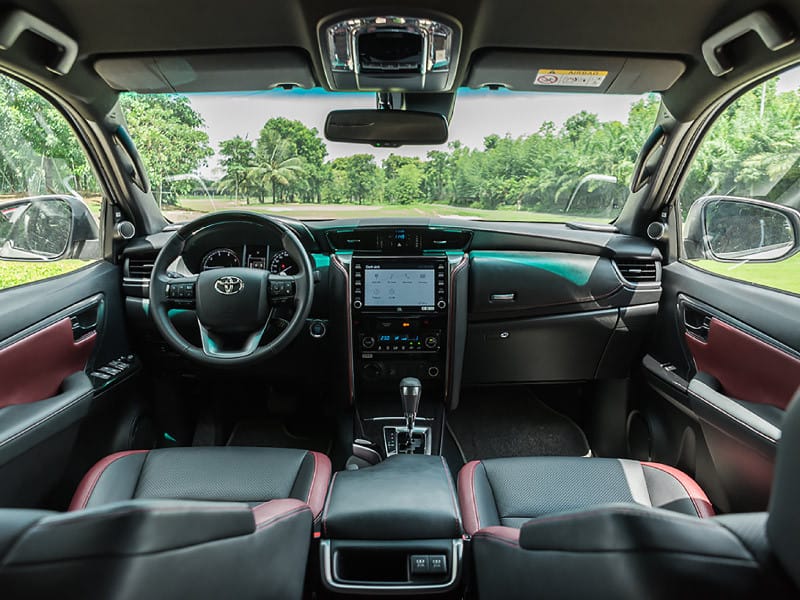 Không gian nội thất Toyota Fortuner với màn hình giải trí trung tâm 8 inch và vô lăng bọc da, minh họa thông số kỹ thuật tiện nghi.