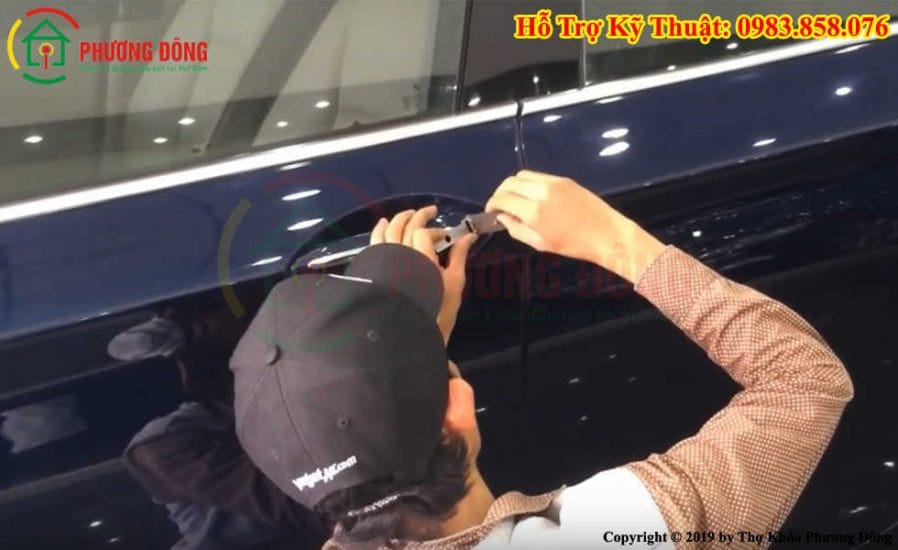 Kỹ thuật viên thực hiện mở khóa ô tô bằng công cụ chuyên biệt