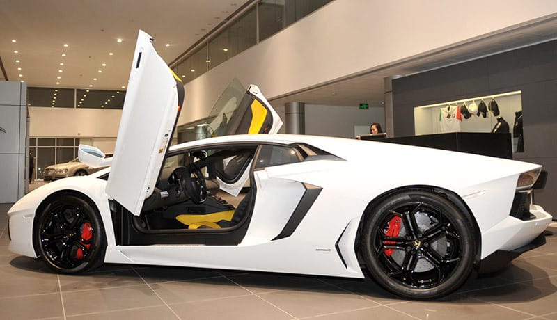Lamborghini Huracan màu vàng tươi, với thiết kế khí động học và mạnh mẽ, đậu trên một con đường lát đá
