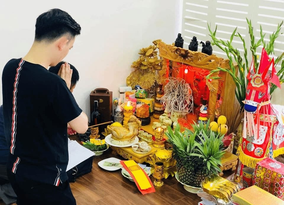 Mâm cúng Thần Tài đơn giản với hoa quả, nhang đèn, chuẩn bị cho việc bấm biển số xe may mắn.