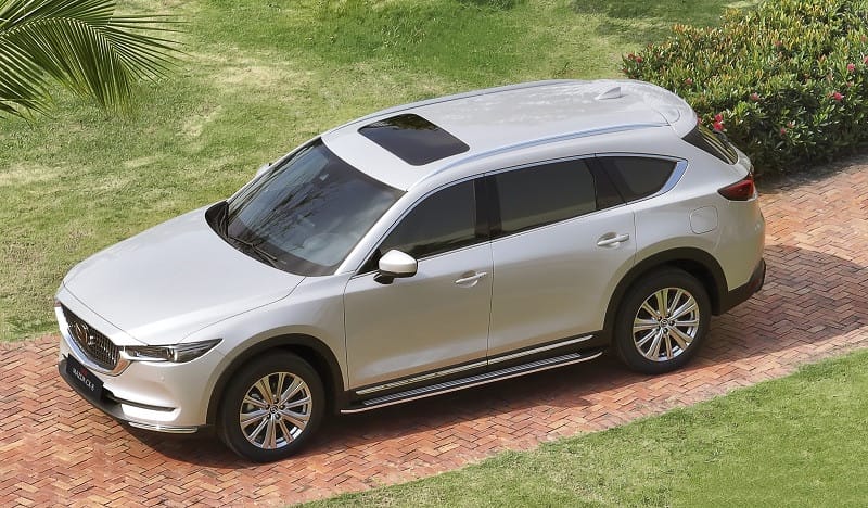 Mazda CX-8 màu trắng đang đỗ, thể hiện khả năng tiết kiệm nhiên liệu ưu việt của công nghệ Skyactiv.