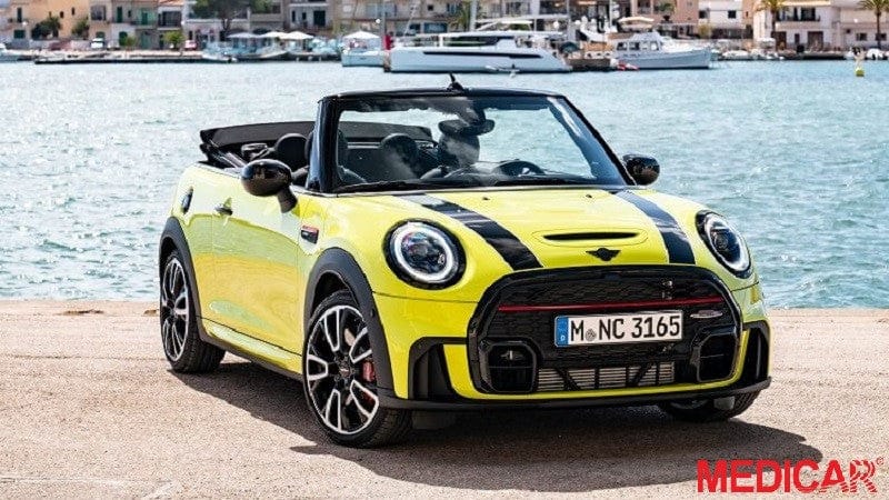 Một chiếc Mini Cooper Convertible màu đỏ đang chạy trên đường ven biển