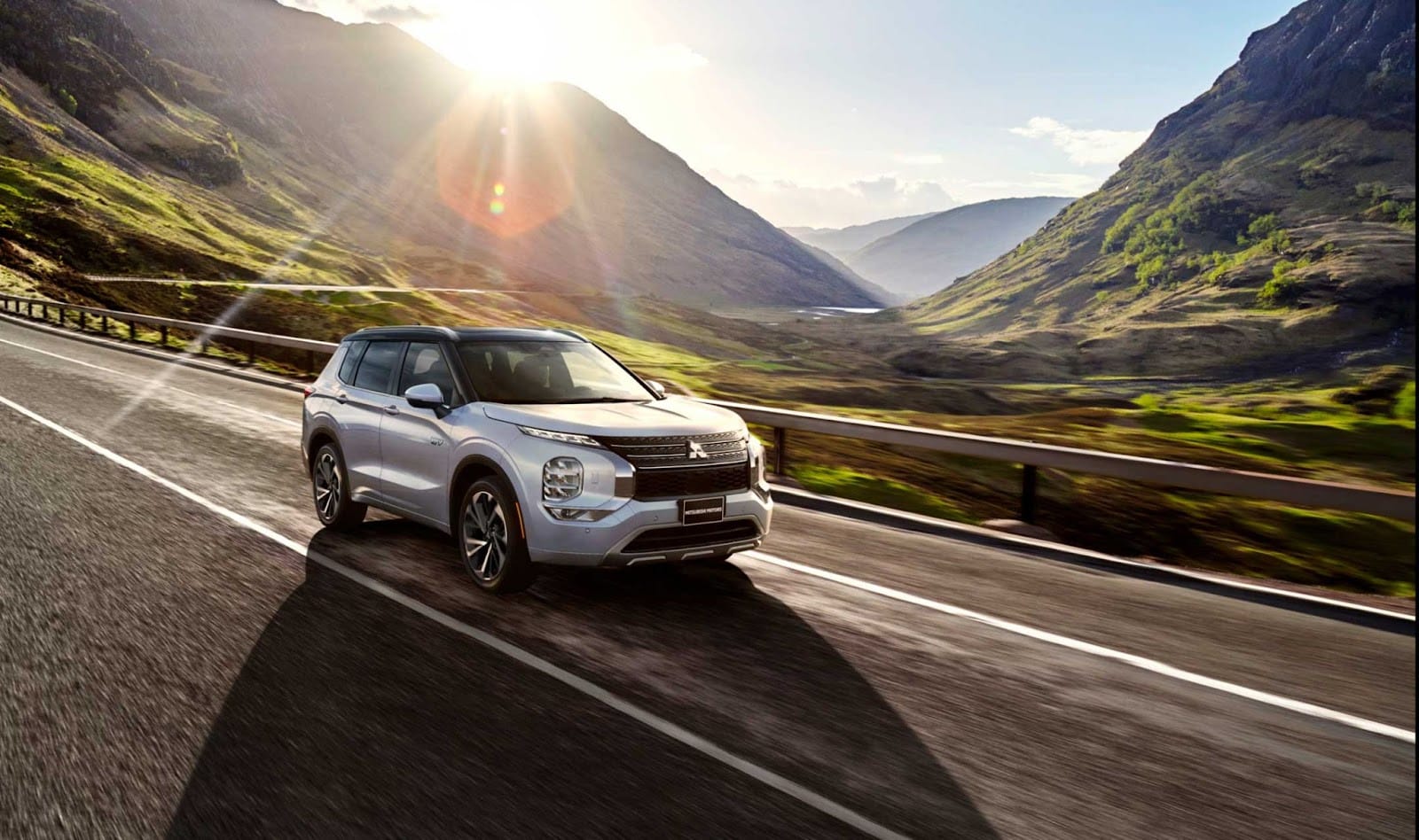 Một chiếc xe Mitsubishi Outlander PHEV màu trắng đang đậu ngoài trời, trưng bày khả năng của dòng xe plug-in hybrid