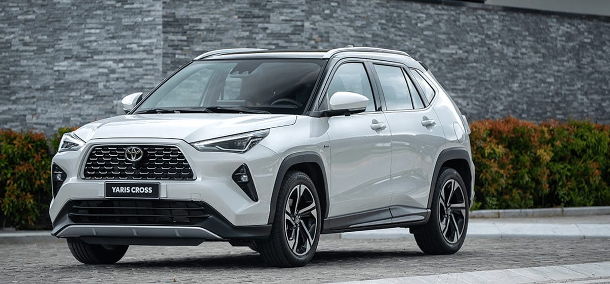Một chiếc xe Toyota Yaris Cross HEV màu trắng đang đậu trên đường, minh họa dòng xe hybrid nhỏ gọn
