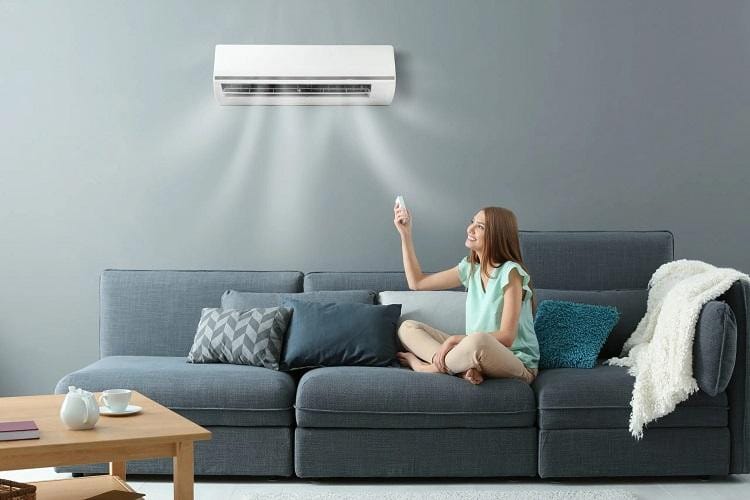 Một gia đình nhỏ đang thư giãn trong phòng khách với máy lạnh ở chế độ Eco, không gian mát mẻ dễ chịu