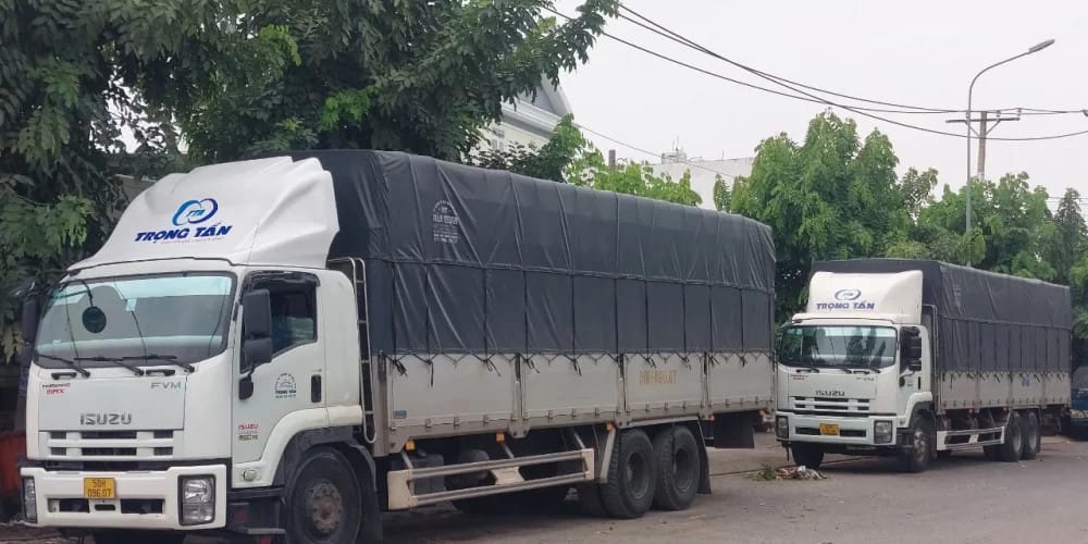 Một lái xe tải đang kiểm tra lốp xe trước chuyến đi dài, nhấn mạnh tầm quan trọng của việc tuyển lái xe tải chạy bắc nam có trách nhiệm.
