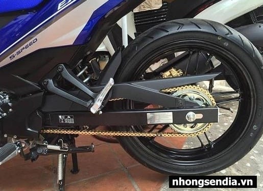 Một người thợ đang kiểm tra độ căng của dây xích xe máy bằng tay