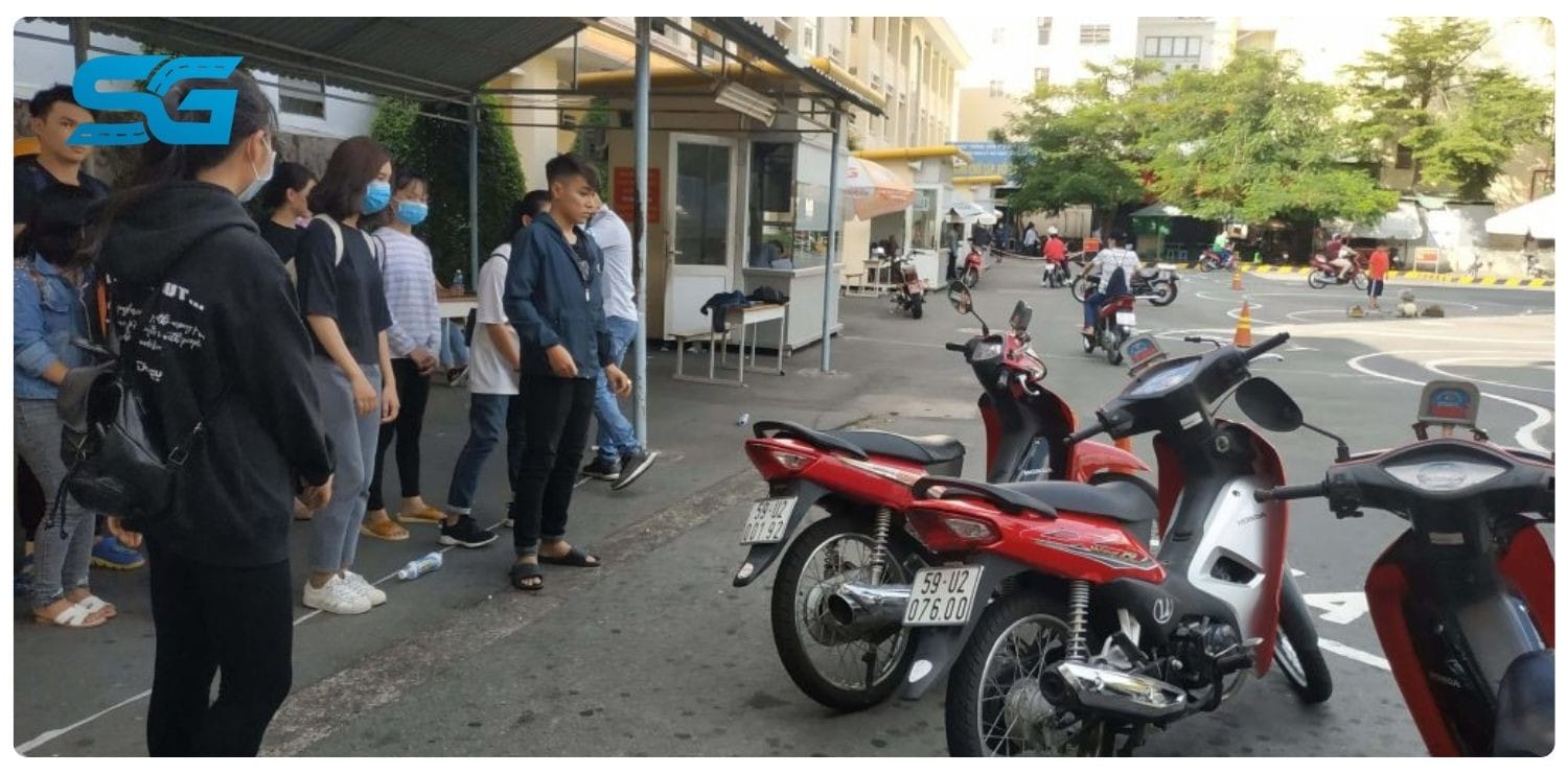 Một nhóm học viên đang đứng trước cổng trung tâm sát hạch lái xe
