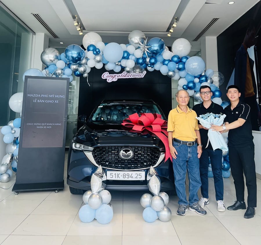 Người đàn ông chỉ tay vào màn hình hiển thị ưu đãi xe Mazda CX-5 màu đỏ