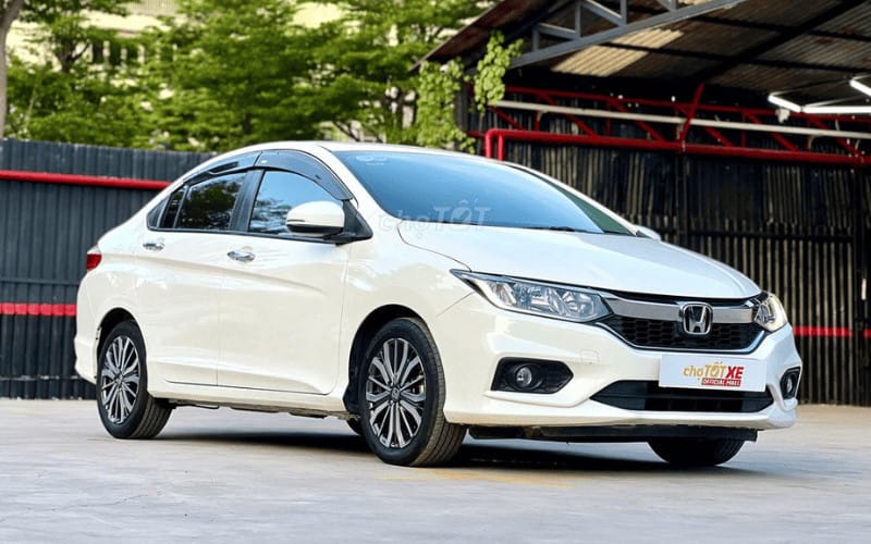 Người lái đang lái chiếc Honda City cũ màu trắng trên đường