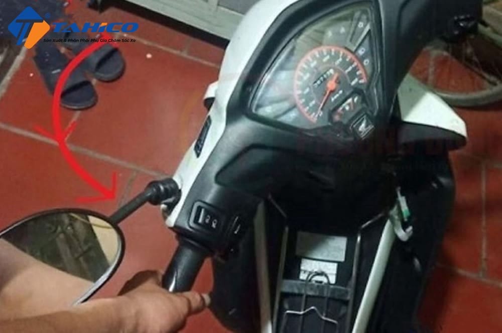 Người lái xe đang thực hiện thao tác khóa cổ xe máy bằng chìa khóa