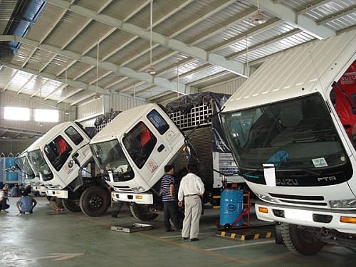 Người mua đang kiểm tra thân xe để phát hiện vết lồi lõm trên một chiếc xe tải cũ tại Hà Nội.