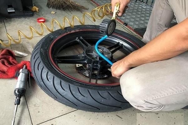 Người thợ đang tư vấn lốp xe máy cho khách hàng