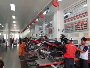 Người thợ sửa xe đang kiểm tra hệ thống phun xăng điện tử, một nguyên nhân phức tạp khiến xe máy đề không lên