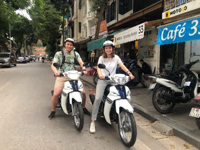 Người thuê xe đang kiểm tra lốp xe máy cẩn thận trước chuyến đi tại Nghĩa Lộ