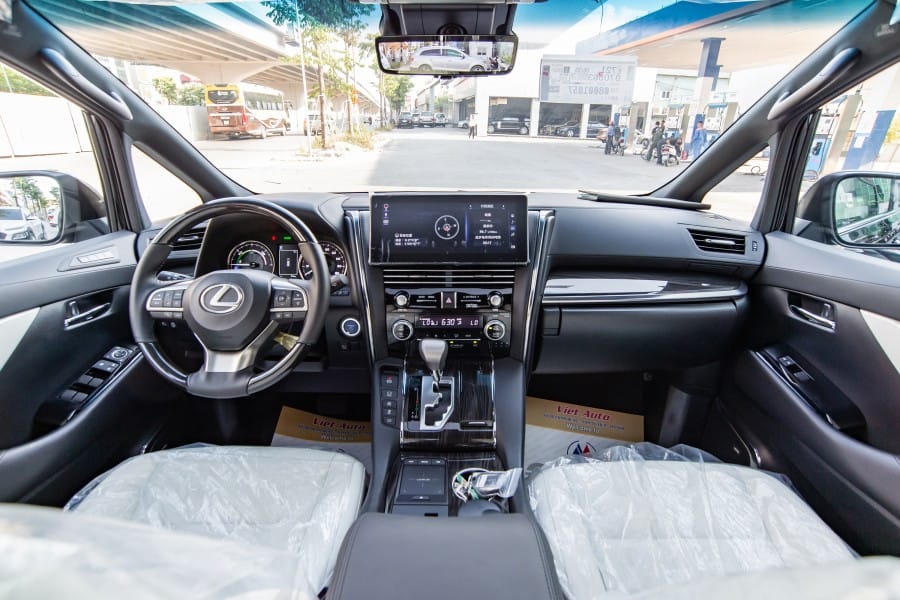 Nội thất Lexus LM300h với vô lăng bọc da ốp gỗ và màn hình giải trí lớn