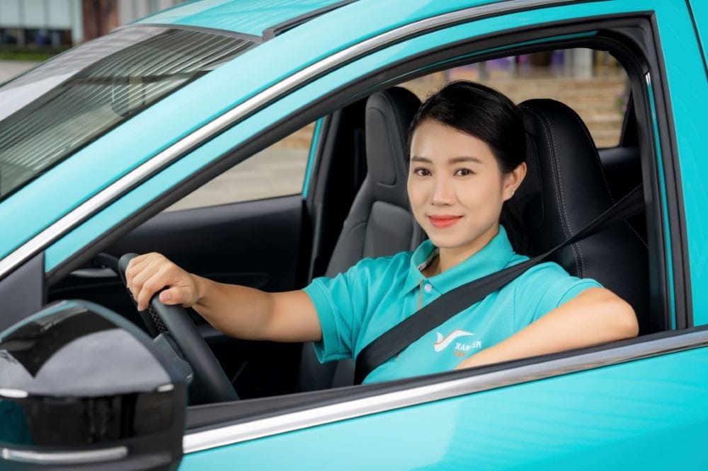 Nữ tài xế taxi VinFast tự tin lái xe, minh chứng cho cơ hội bình đẳng và hỗ trợ đào tạo chuyên nghiệp.