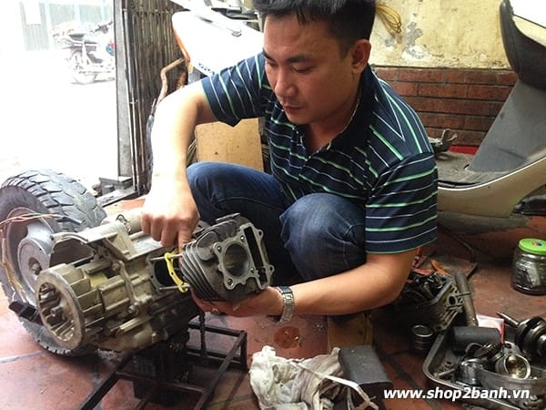 Que thăm dầu đang được kiểm tra mức nhớt xe máy