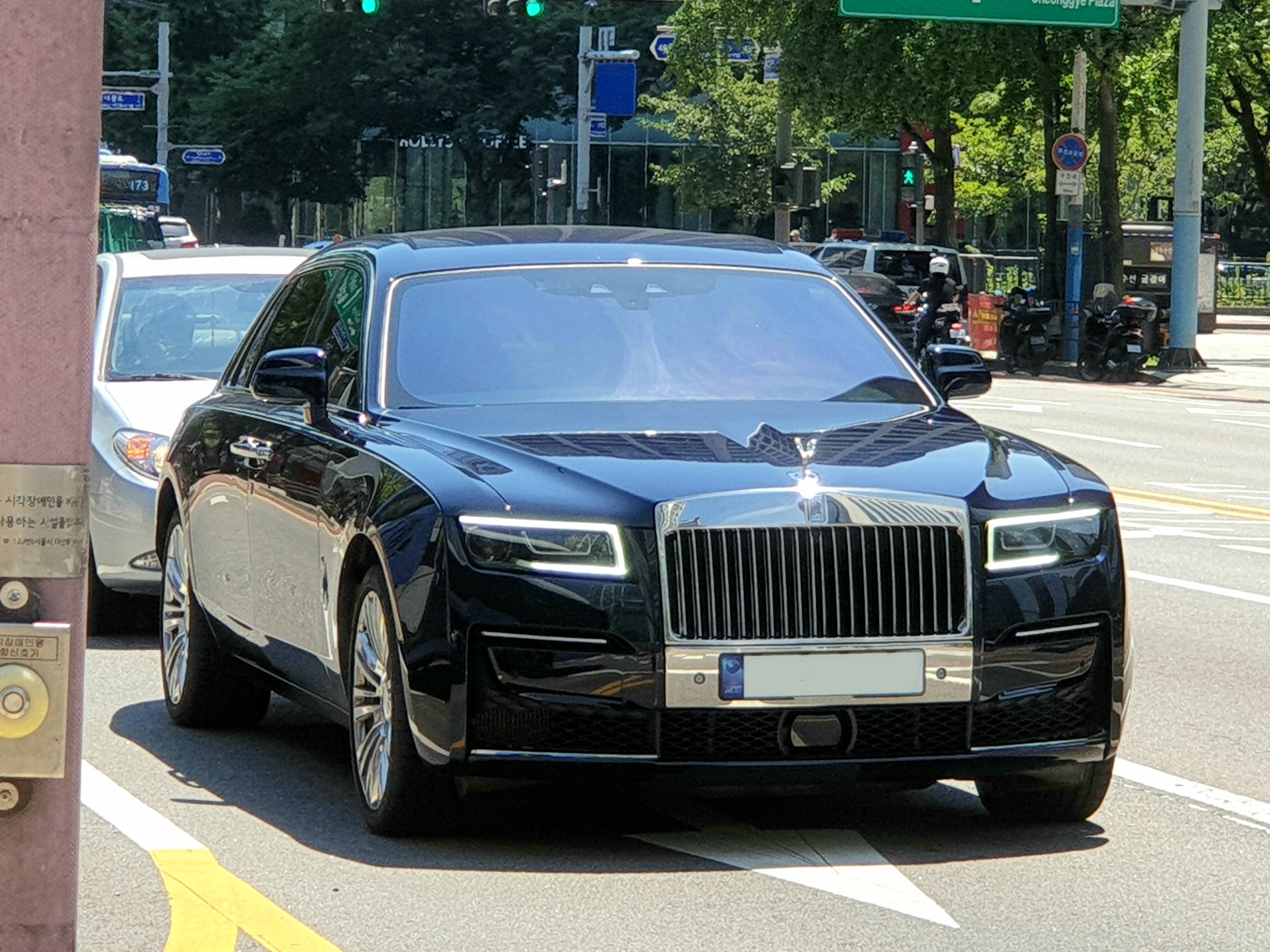 Rolls-Royce Ghost màu đen bóng loáng, đậu trước một tòa nhà cổ điển, thể hiện sự sang trọng và quyền uy
