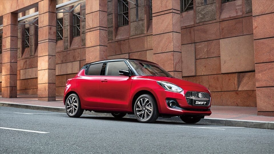 Suzuki Swift màu đỏ đỗ trên đường