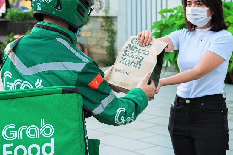 Tài xế đang sử dụng ứng dụng Grab trên điện thoại, tìm hiểu **chi phí đăng ký chạy Grab**.