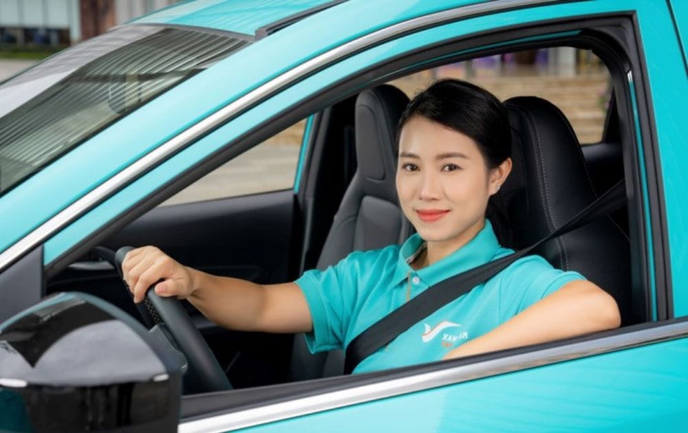 Tài xế taxi xanh Hà Nội chuyên nghiệp trên xe điện hiện đại