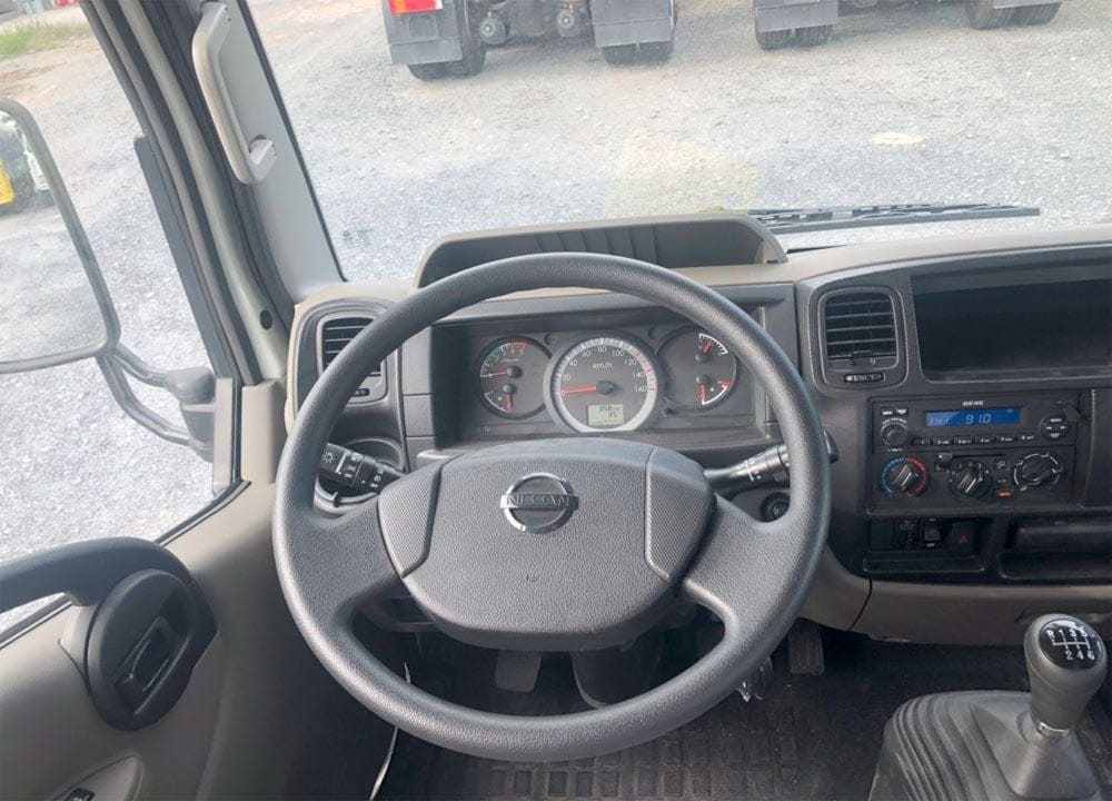 Tay lái và bảng điều khiển của xe tải Nissan, thể hiện thiết kế hiện đại của ô tô xe tải