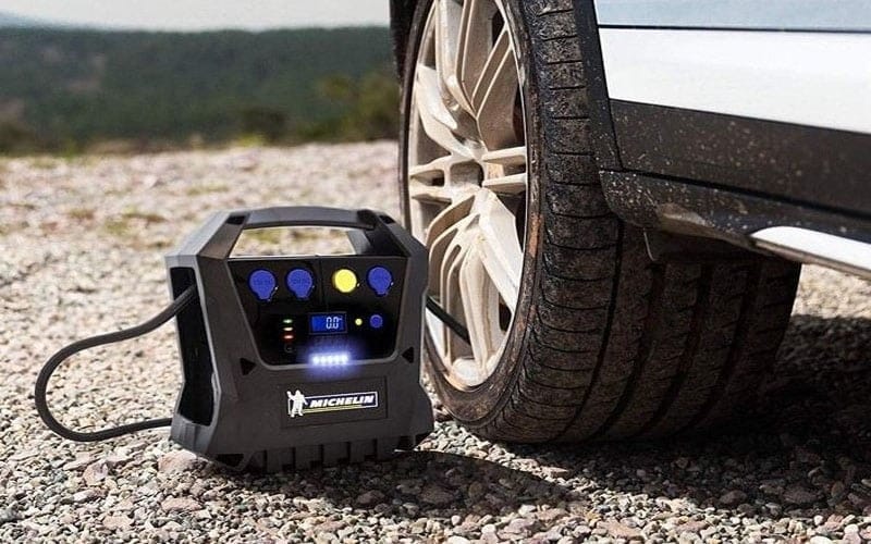 Thiết bị bơm lốp xe 7 chỗ và tay đang điều chỉnh van
