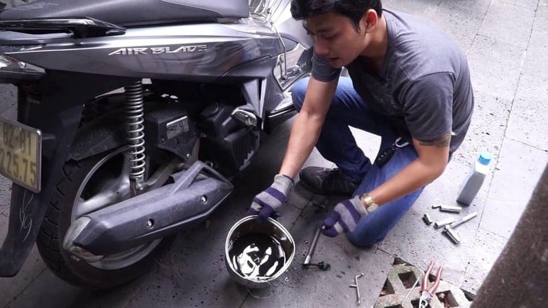 Thợ đang thay nhớt cho xe máy bị ngập nước, cần xử lý kịp thời