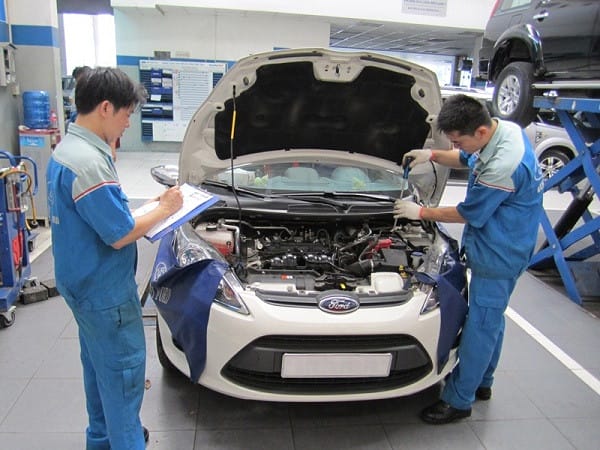 Thợ kỹ thuật đang bảo dưỡng ắc quy ô tô tại trung tâm dịch vụ