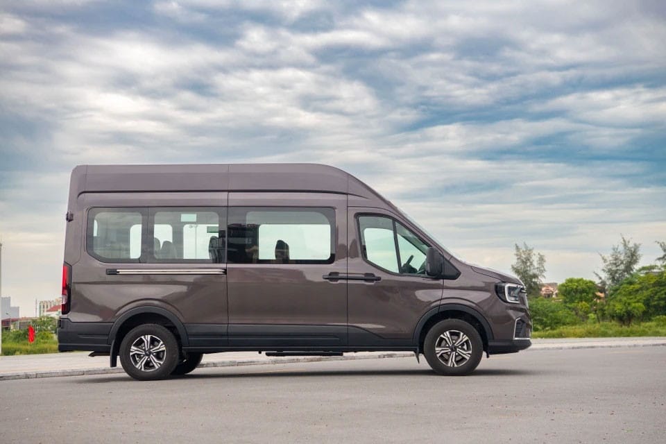 Xe 16 chỗ Ford Transit màu trắng chạy trên đường với thiết kế lưới tản nhiệt mới