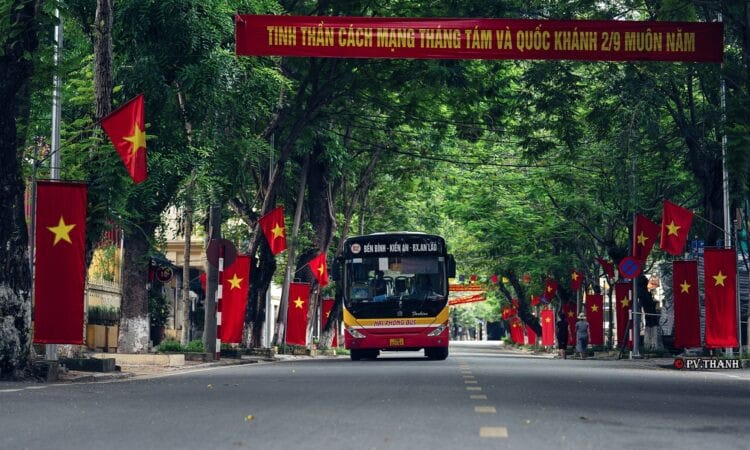 Xe buýt màu xanh đang di chuyển trên đường đến bến xe Vĩnh Niệm Hải Phòng
