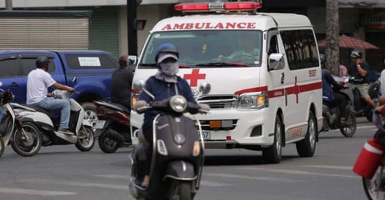 Xe cấp cứu đang bật đèn tín hiệu ưu tiên trên đường phố đông đúc, minh họa quy định về thứ tự xe ưu tiên